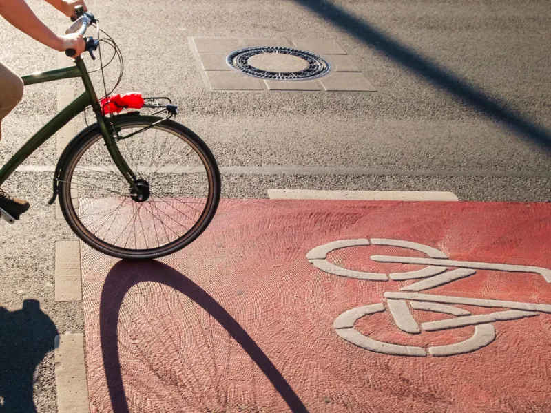 Eine radfahrende Person auf einem Radweg.