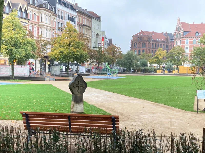 Eine neugestaltete Gr&uuml;nfl&auml;che. Im Hintergrund Wohnh&auml;user.