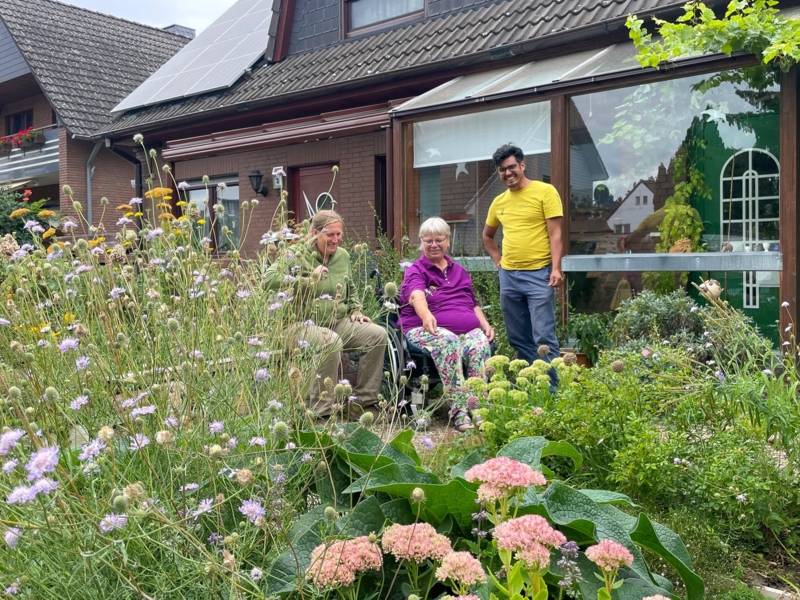 Drei Menschen in einem Garten.