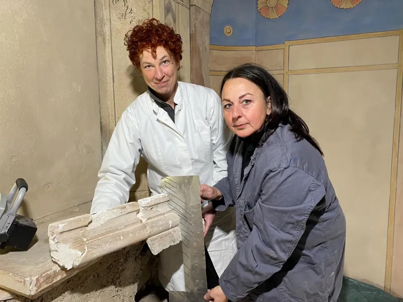 Zwei Personen mit historischem Gestein.