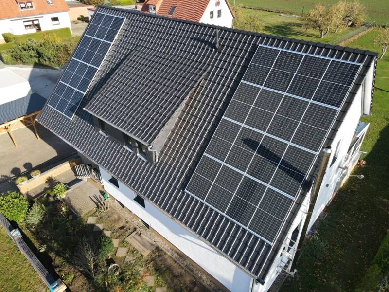 Luftaufnahme von einem Hausdach, auf dem eine Photovoltaik-Anlage zu sehen ist