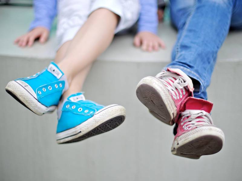 Nahaufnahme von hellblauen und rosa Turnschuhen von zwei Jugendlichen
