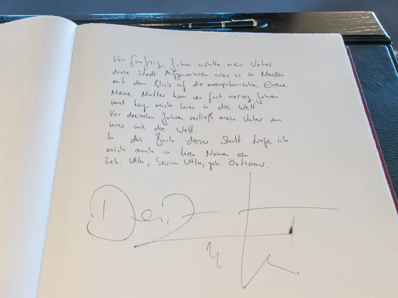 Ein handschriftlicher Eintrag im Goldenen Buch der Stadt: "Vor f&uuml;nfzig Jahren w&auml;hlte mein Vater diese Stadt. Aufgewachsen war er in Mardin mit dem Blick auf die mesopotamische Ebene. Meine Mutter kam vor fast vierzig Jahren und trug mich hier in die Welt. Vor dreizehn Jahren verlie&szlig; mein Vater von hier aus die Welt. In das Buch dieser Stadt trage ich mich auch in ihren Namen ein. Zeki Utlu; Sevim Utlu, geb. &Ouml;ztimer." (Unterschrift Deniz Utlu)