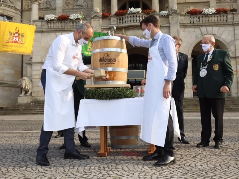 Zwei M&auml;nner vor einem Bierfass.