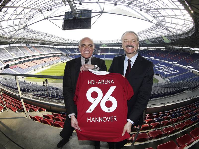 96-Präsident Martin Kind (links) und Dr. Christian Hinsch (stellvertrender Vorstandsvorsitzender der HDI-Gruppe) mit einem 96-Trikot in der Nordkurve der Arena.