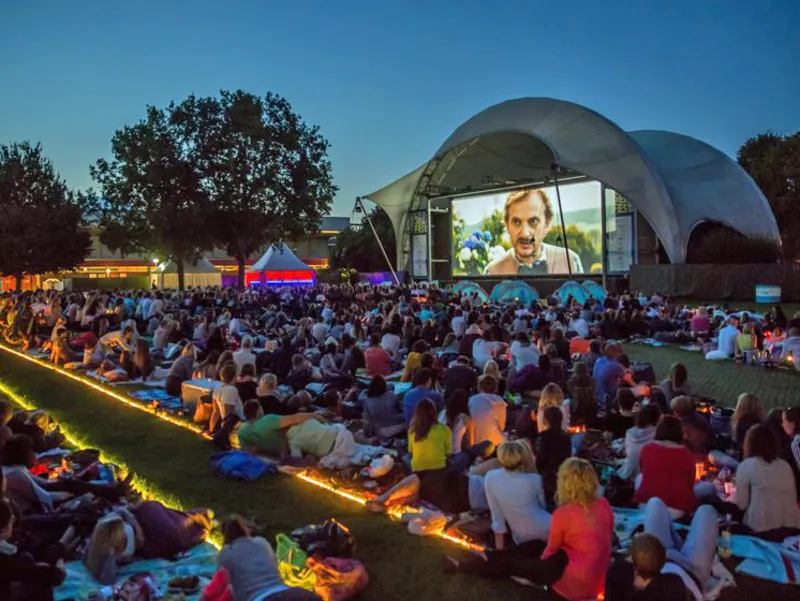Leute im Freien vor einer gro&szlig;en Leinwand