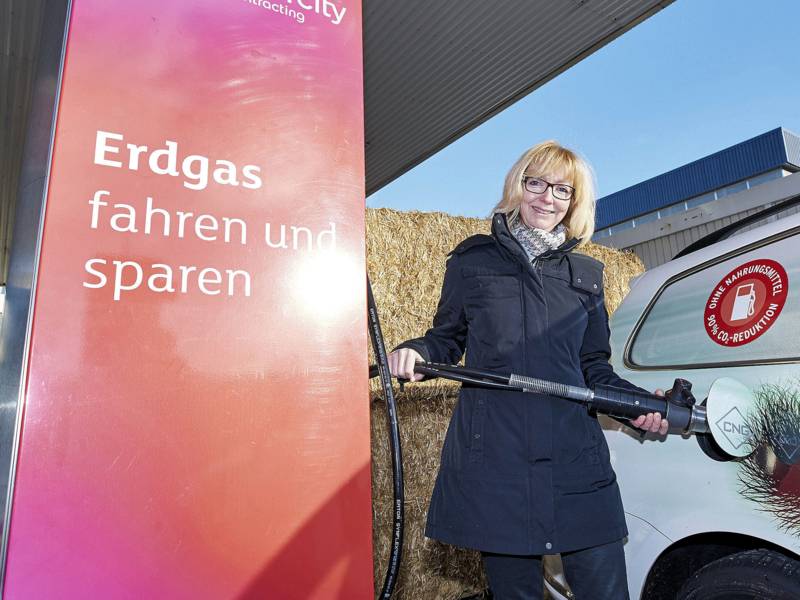 Frau an Tankstelle