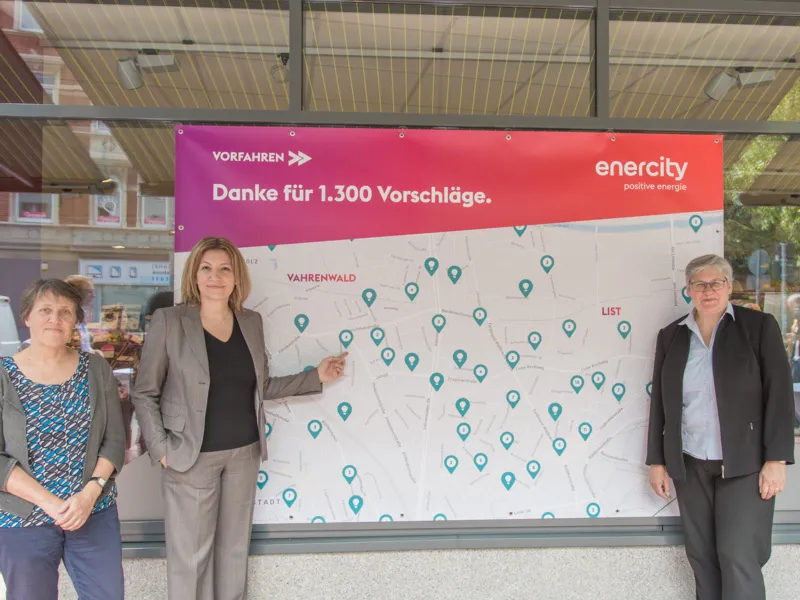 Drei Frauen stehen vor einem gro&szlig;en Plakat mit der Aufschrift: "Vorfahren. Danke f&uuml;r 1.300 Vorschl&auml;ge" und einem Stadtplan.