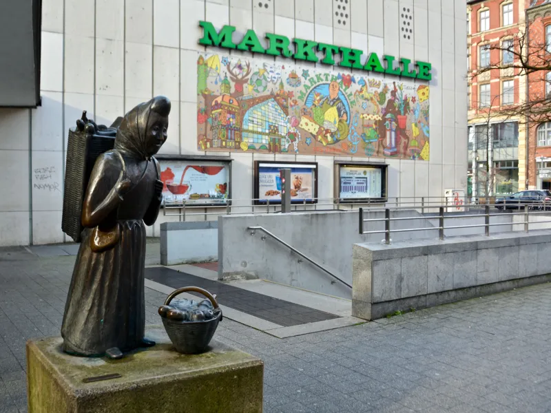 Bronzefigur, die eine Marktfrau mit Korb darstellt