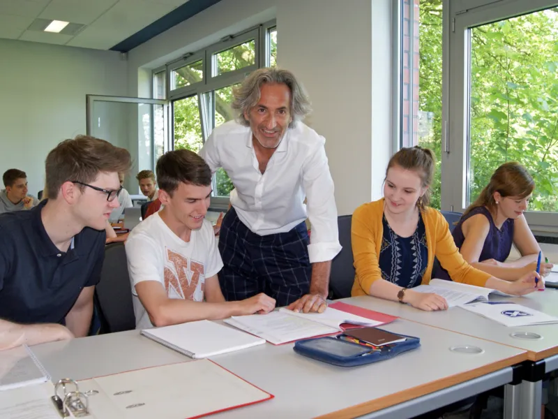 Foto: Prof. Dr. Christof Zwecker mit Studierenden der Fachhochschule f&uuml;r die Wirtschaft im Unterrichtsraum.