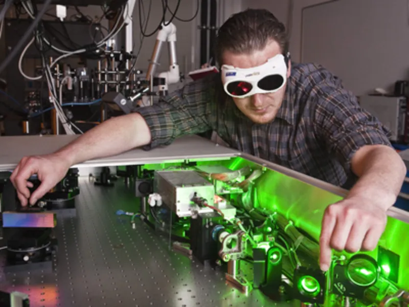 Ein Mann mit Schutzbrille f&uuml;hrt ein physikalisches Experiment durch.