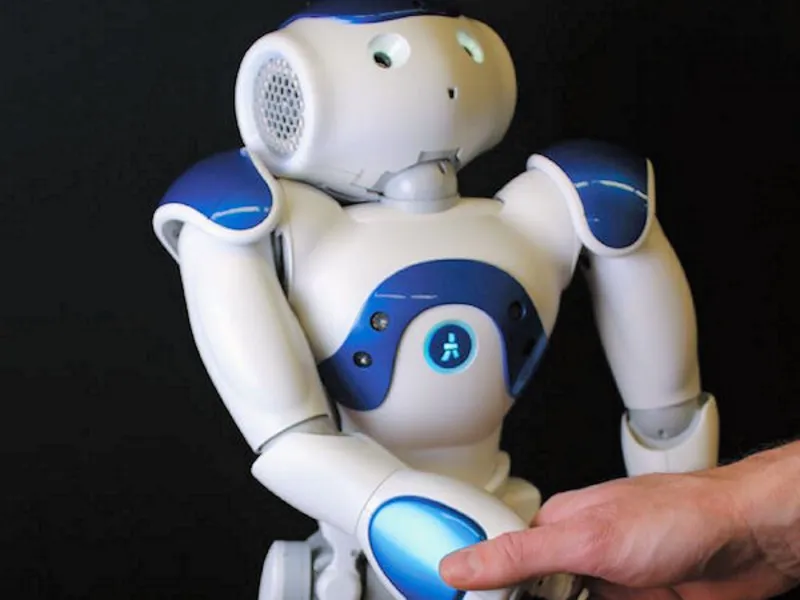 Roboter gibt menschlicher Hand die Hand.