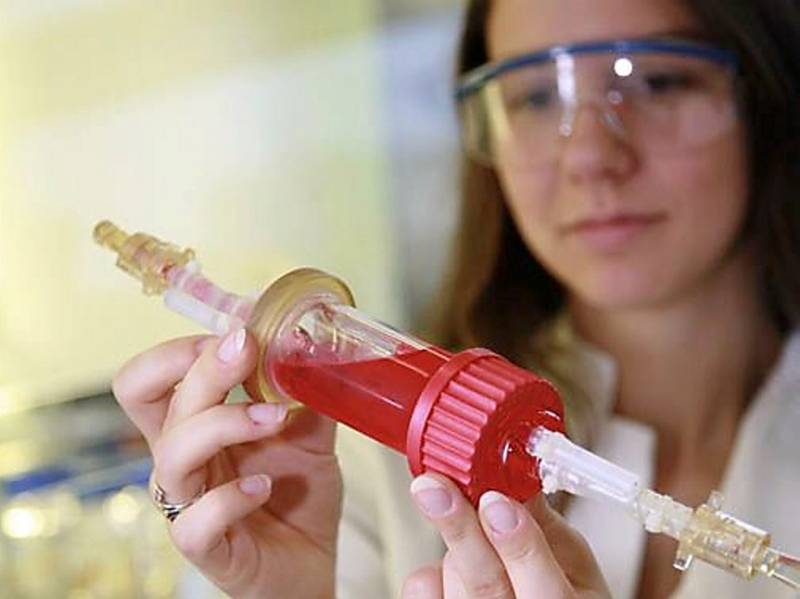 Forscherin hält eine Spritze in den Händen.
