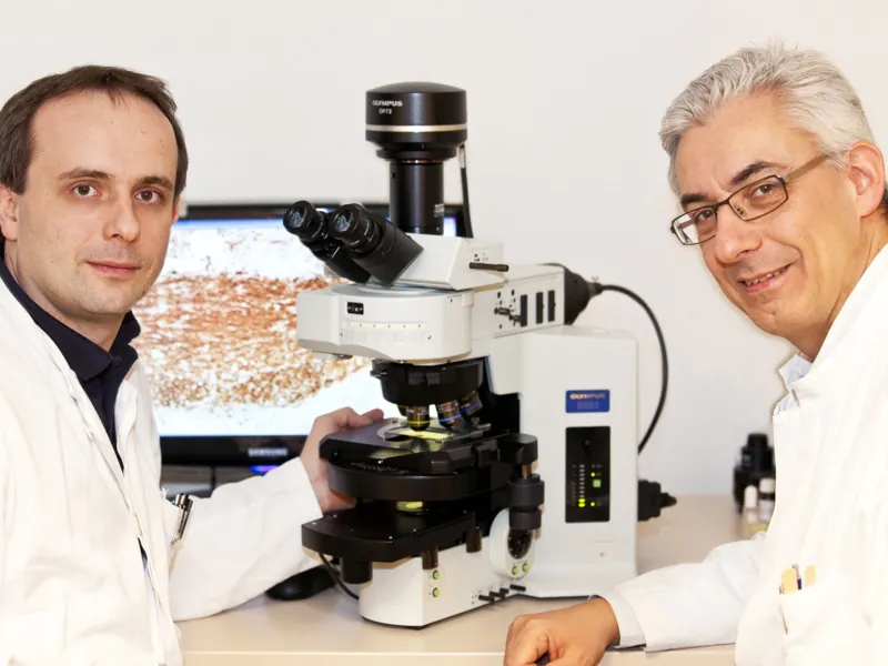 Zwei Wissenschaftler mit einem Elektronenmikroskop.