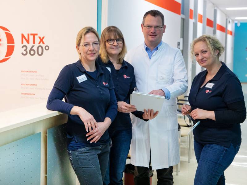 Drei Frauen und ein Mann in wei&szlig;em Kittel.