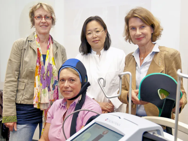 Vier Frauen mit medizinischen Ger&auml;te, eine Frau tr&auml;gt eine Haube.