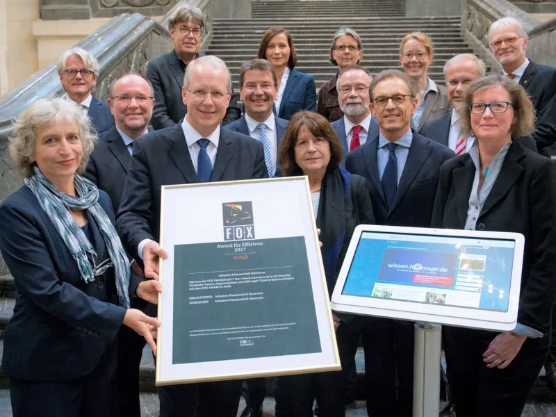Menschengruppe mit Urkunde