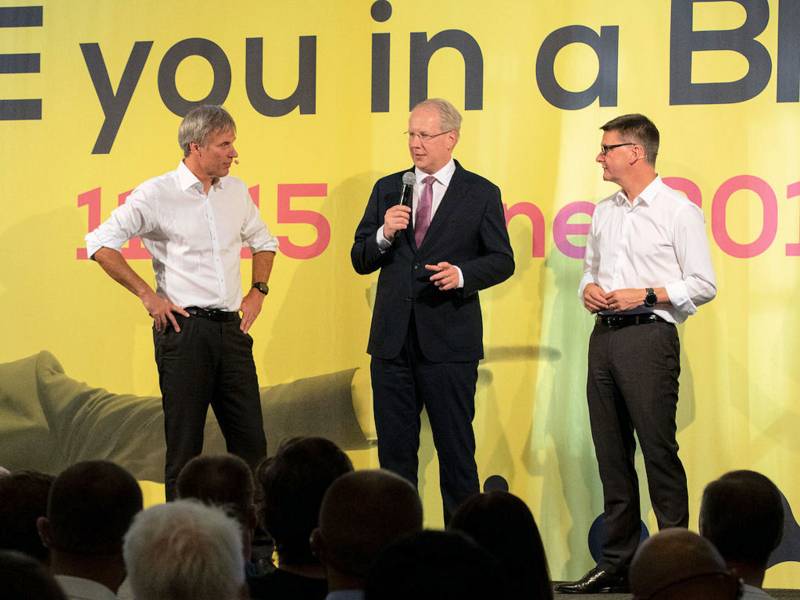 Drei Männer stehen auf einer Bühne