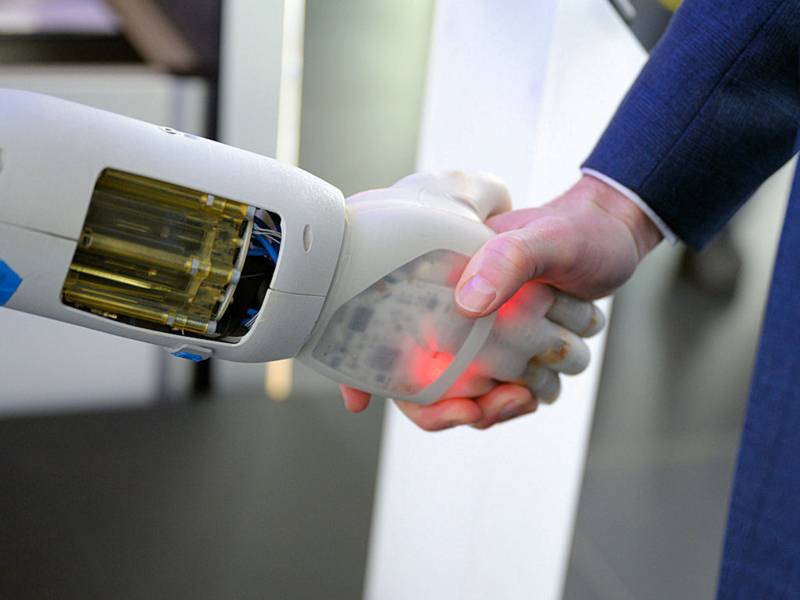 Händeschütteln einer menschlichen Hand mit einer Roboterhand 