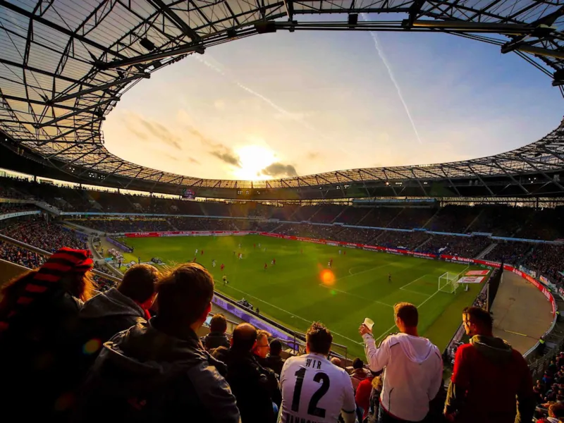 Innenraum eines Fu&szlig;ballstadion im Abendlicht.