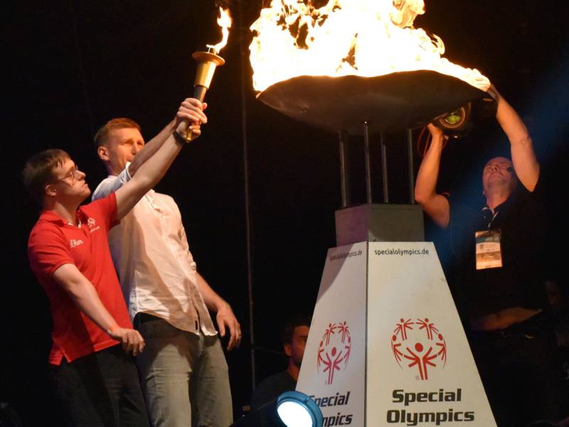 Foto: Jörg Trute und Per Mertesacker entzünden die olympische Flamme in der TUI-Arena. 