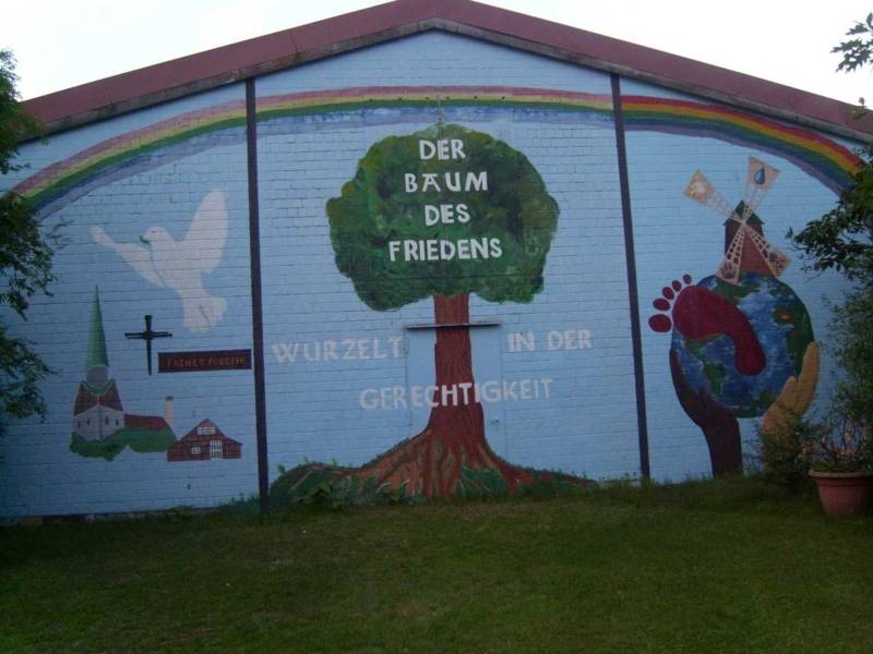 Bunt bemalte Scheunenwand mit einem Baum und der Schrift Der Baum des Friedens wurzelt in der Gerechtigkeit