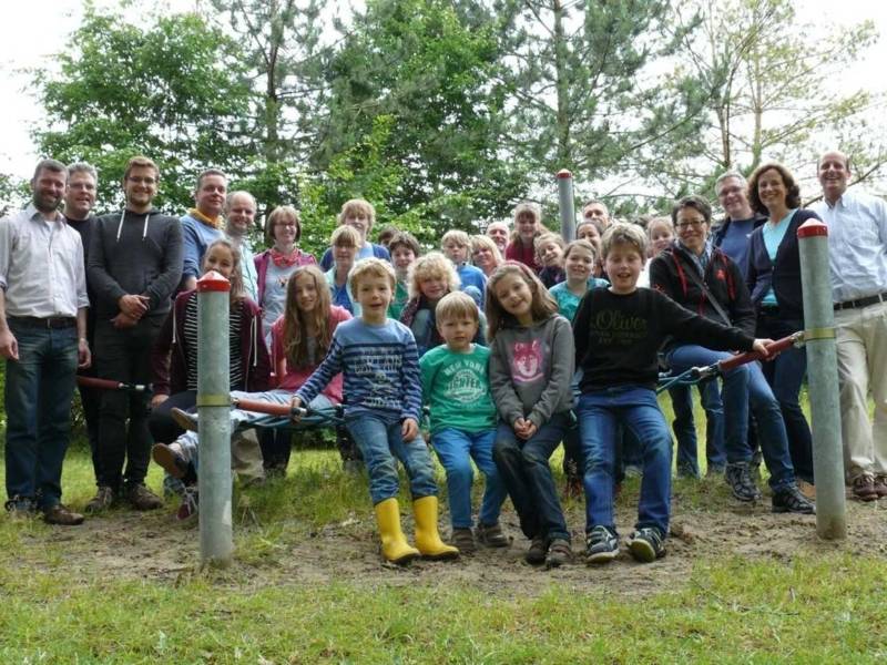 Große Gruppe von Kindern und Erwachsenen auf einer Rasenfläche