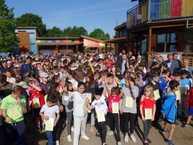 Große Gruppe von Kindern zwischen bunten Gebäuden