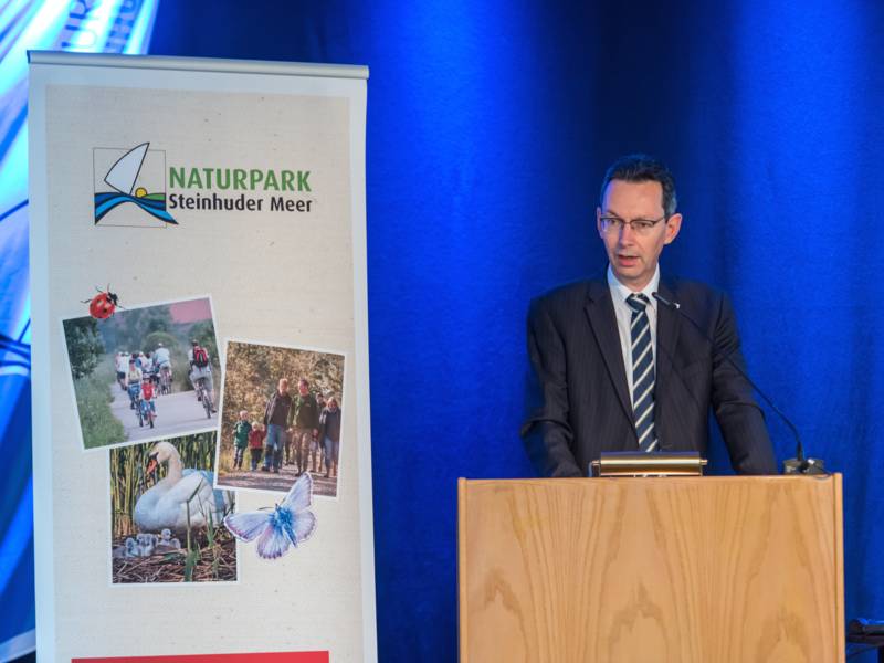 Ein Mann steht hinter einem Rednerpult.