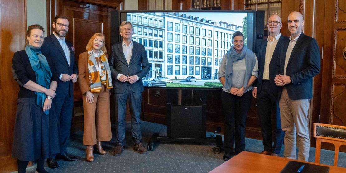 Menschengruppe vor großem Bildschirm