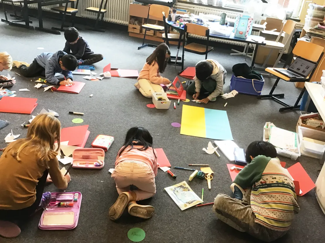 Kinder der International School Hannover Region malen und basteln Friedenstauben.