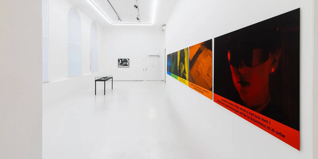 Ein weißer Ausstellungsraum mit fünf großflächigen bunten Fotos an den Wänden