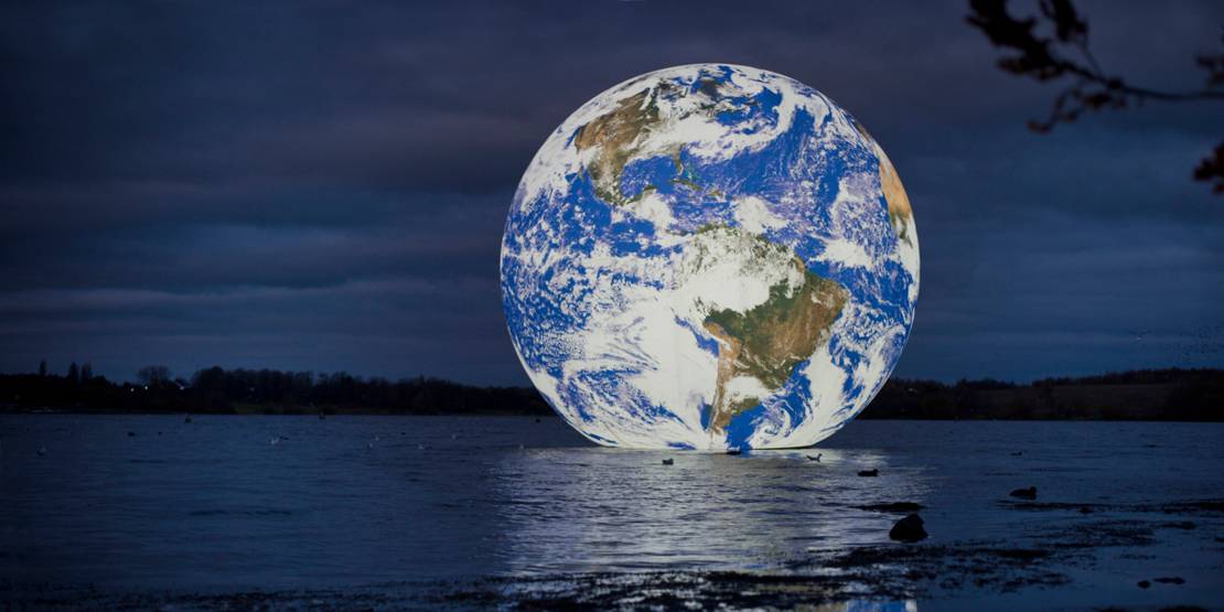 Beleuchteter Globus auf einem See.