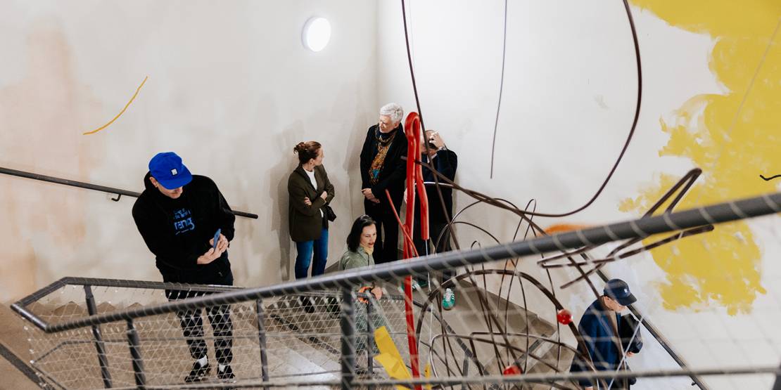 Menschen in einem kunstvoll gestalteten Treppenhaus