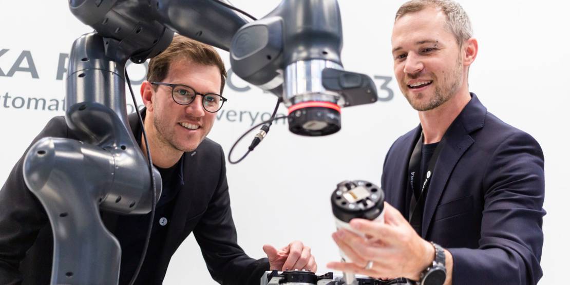 Zwei Männer mit Industrieroboter