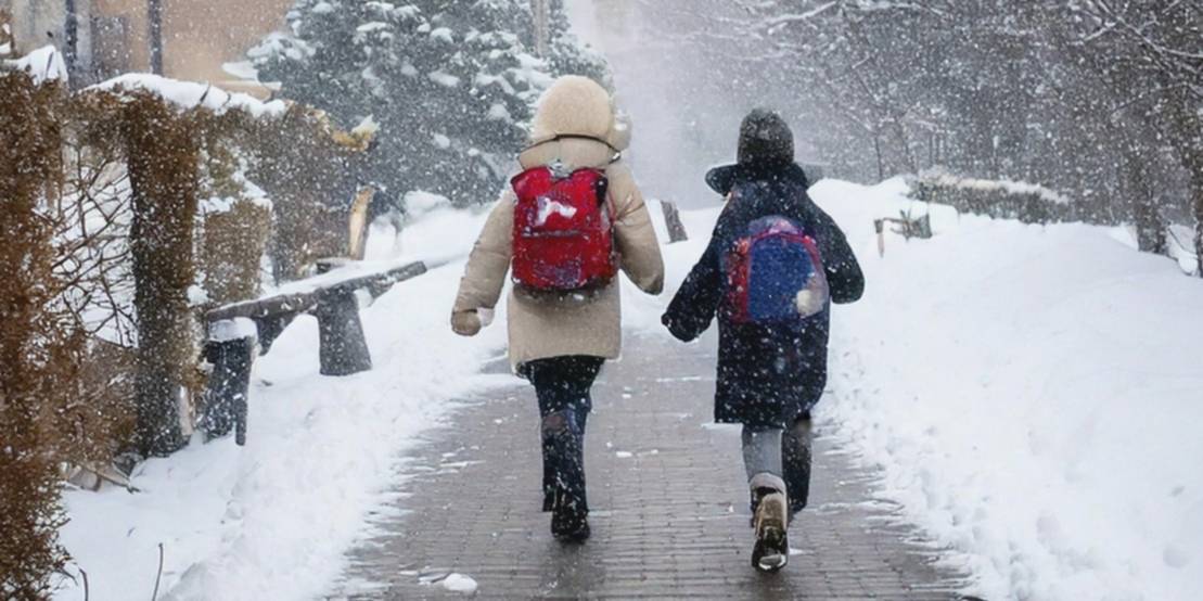 Zwei Kinder laufen auf einem Weg, umsäumt von Schnee und Häusern im Schneegestöber.