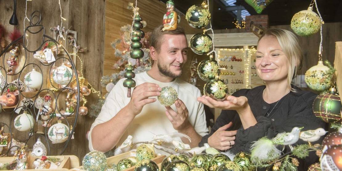 Eine Frau und ein Mann mit Christbaumschmuck.