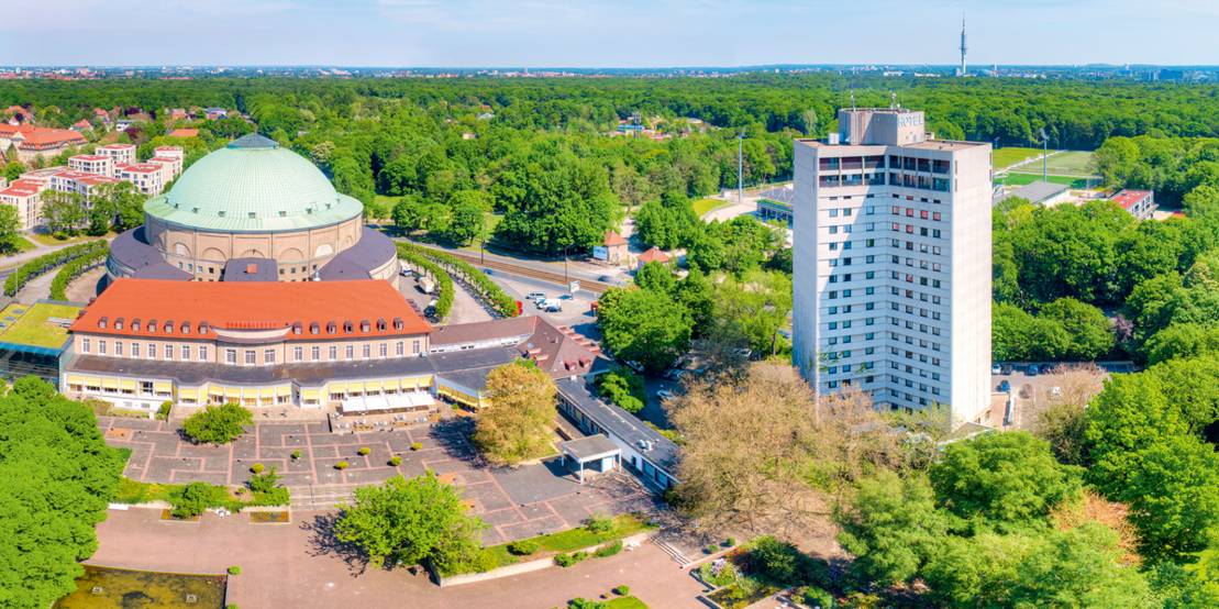 Luftansicht: Kuppelsaal und Hochhaus am Stadtpark, im Hintergrund die Eilenriede.