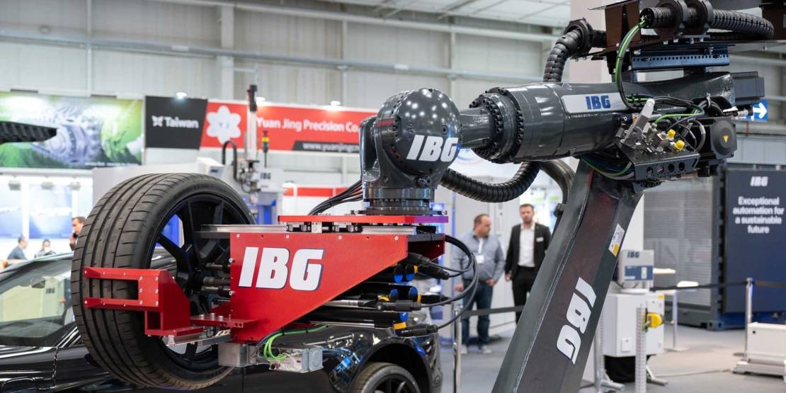 Industrieroboter hält einen Reifen in einer Messehalle