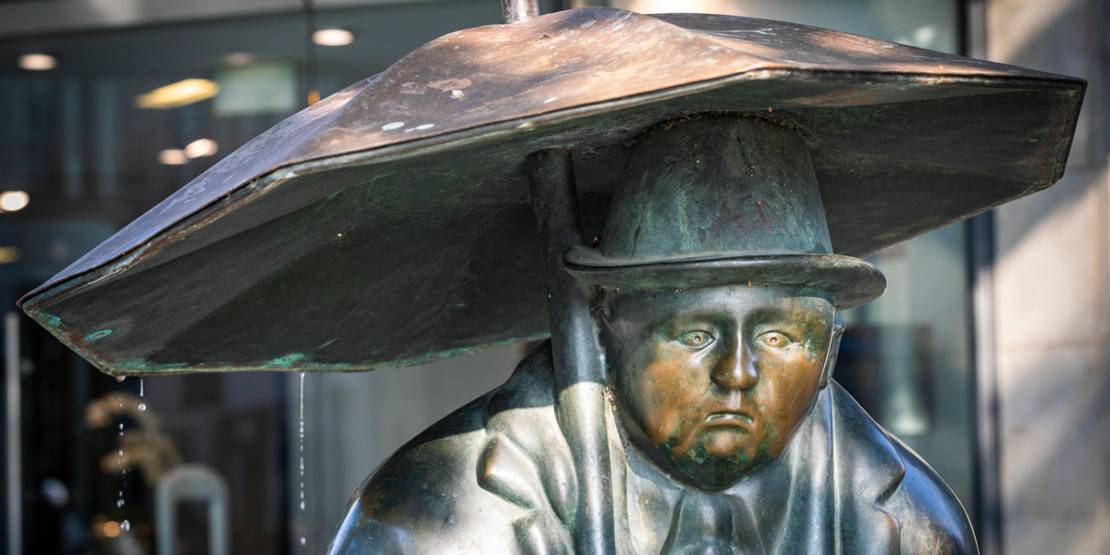 Statue Mann mit Regenschirm