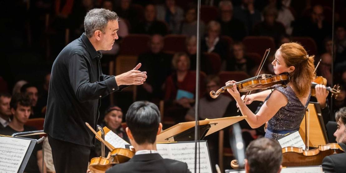 Dirigent und Geigerin mit Sinfonieorchester