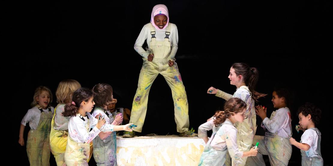 Kinder tanzen mit Buntstiften und Pinseln auf einer Bühne