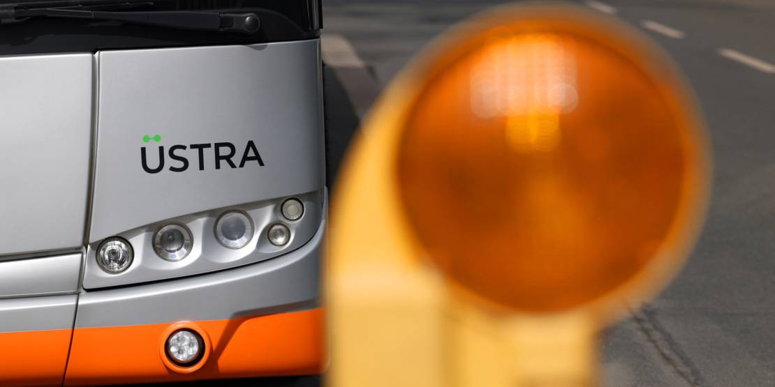 Eine Bake steht zur Markierung vor einem Bus