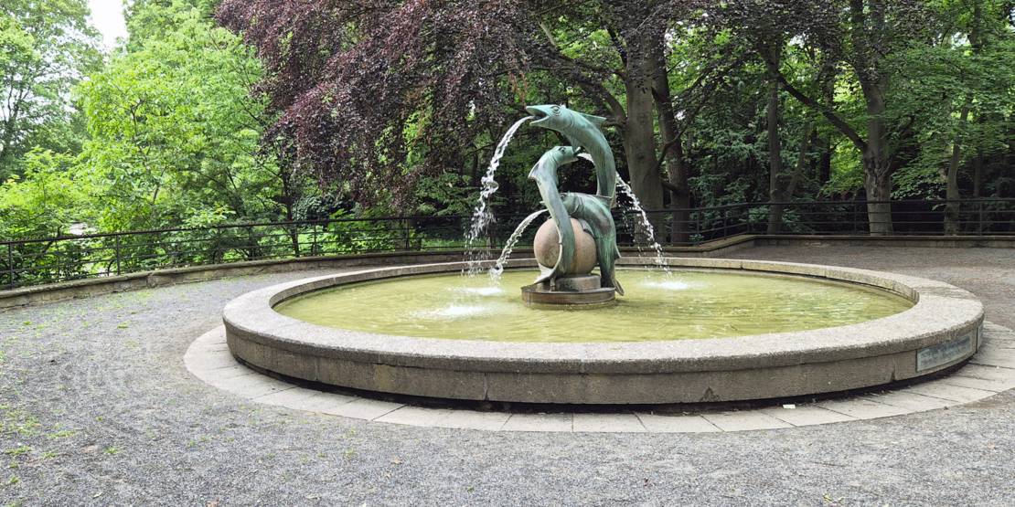 Brunnen mit drei Wasser speienden Fischen