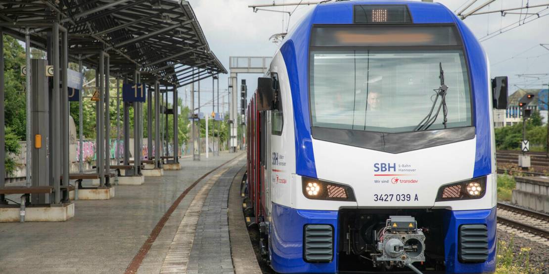 Eine blau-weiße S-Bahn steht an einem Bahnsteig.