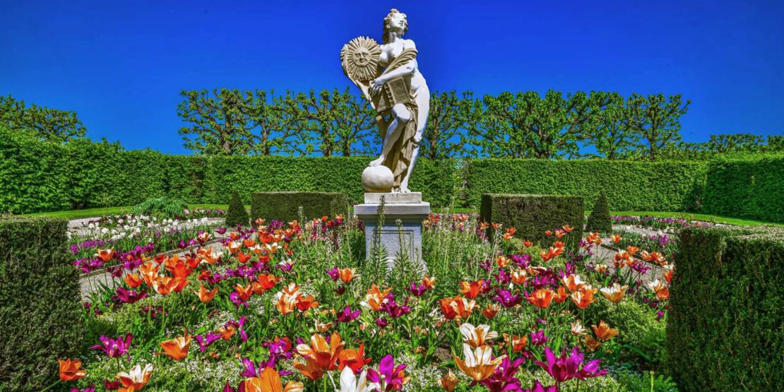Statue der Veritas mit Frühlingsblumen im Großen Garten