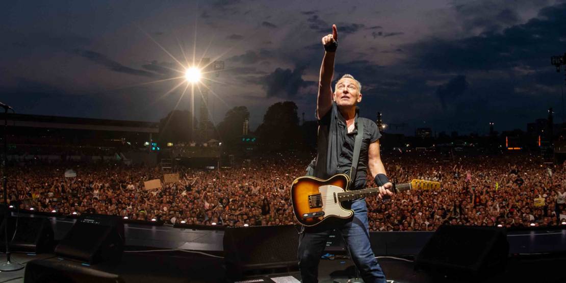 Bruce Springsteen auf einer Bühne vor einer Menschenmasse.