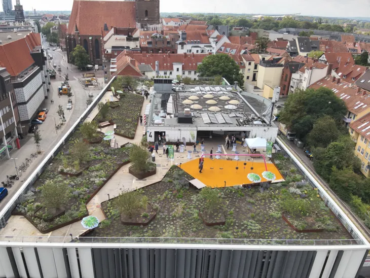Blick auf ein begrüntes Parkhausdach von oben.
