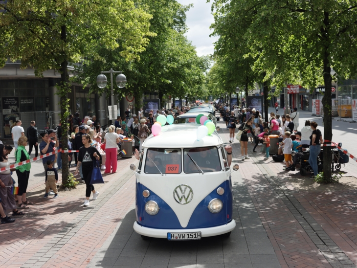 Wagen in einem Festzug. Drumherum viele Menschen.