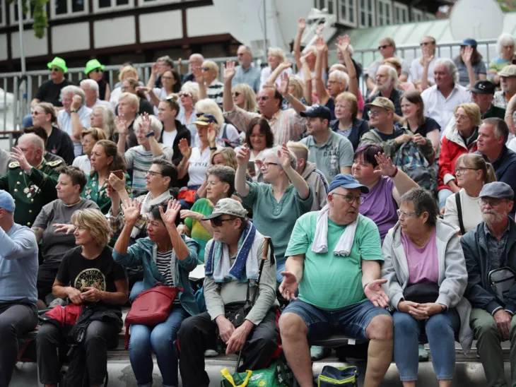 Menschen auf einer Tribüne.